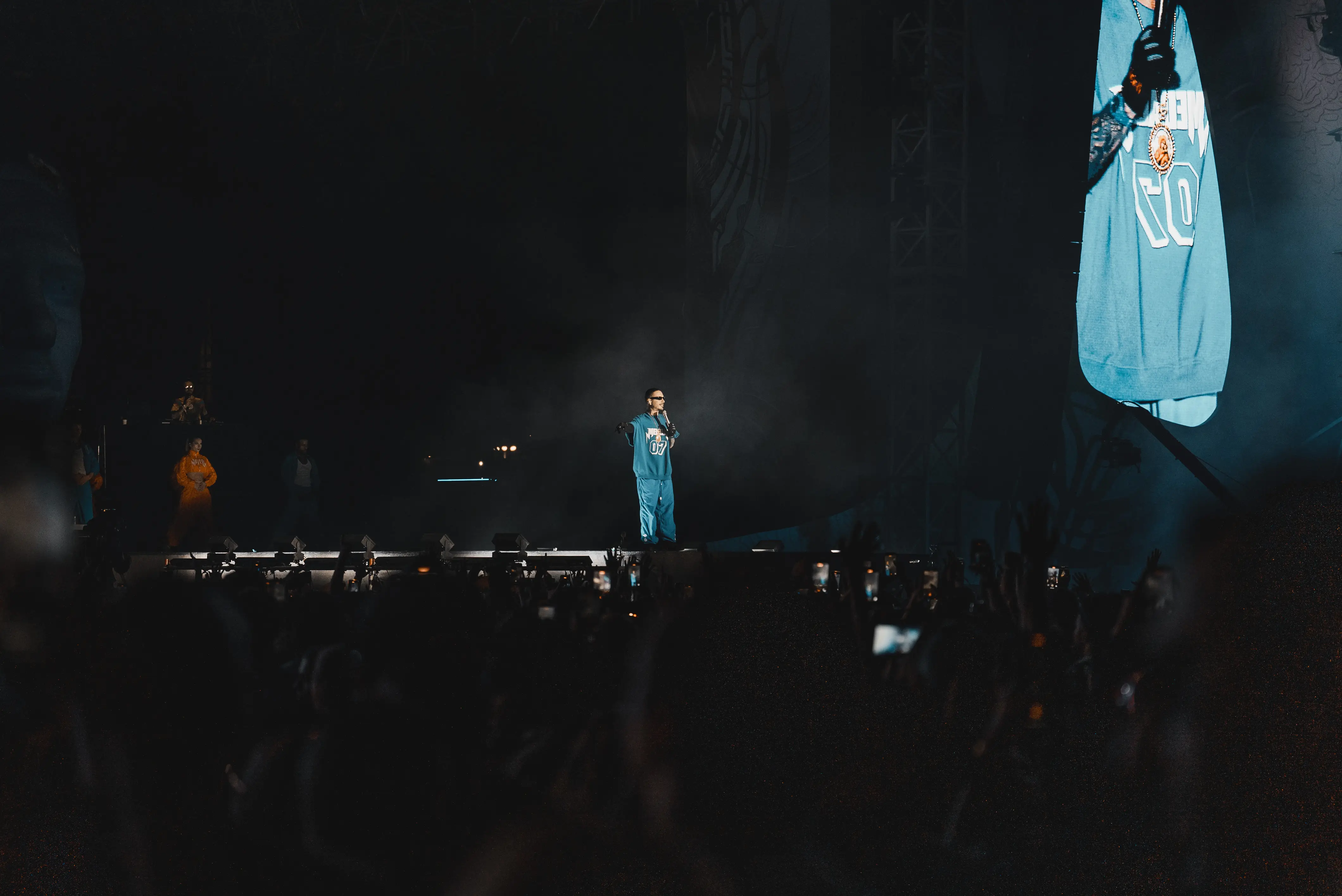 long range photo of crowd cheering with hands up for the artist jbalvin while singing on stage